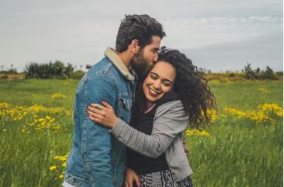 Happy couple sharing a joyful moment in a field of wildflowers