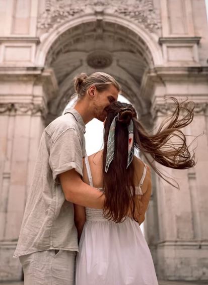 Romantic couple embracing under an ornate architectural archway